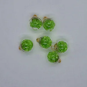 Detail view of 16mm transparent glass balls filled with green faceted beads for jewelry.