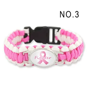 Dettaglio del braccialetto in paracord rosa e bianco con emblema del nastro Fighter