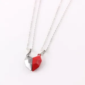 Close-up of split heart-shaped magnetic necklaces in red and silver joined together