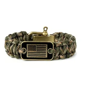 Detalle de pulsera de paracord de camuflaje con placa metálica de bandera de EE. UU.