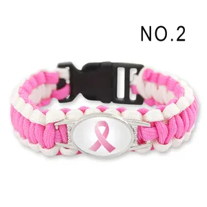 Dettaglio di un braccialetto in paracord fatto a mano con nastro rosa e fibbia nera