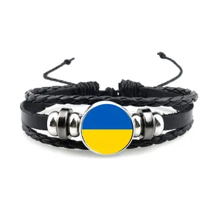 Vista detallada de una pulsera de cuero trenzado hecha a mano con colgante de bandera ucraniana