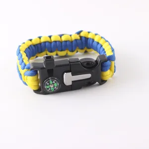 Detail of blue and yellow paracord survival bracelet with compass and whistle buckle