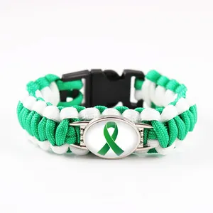 Dettaglio del braccialetto in paracord verde fatto a mano con ciondolo a nastro verde