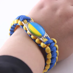 Detail shot of blue and yellow paracord survival bracelet with Ukraine flag emblem.