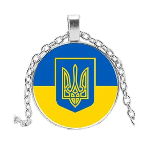 Nahaufnahme der ukrainischen Nationalflagge und des goldenen Wappens auf Glasanhänger.