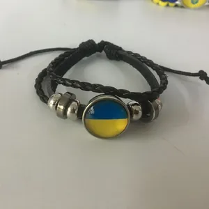 Vista detallada de una pulsera de cuero trenzado con el cabochon de la bandera de Ucrania
