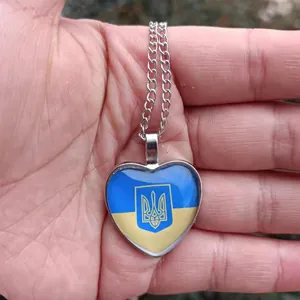 Detailansicht eines herzförmigen Anhängers mit der ukrainischen Flagge und dem Staatswappen
