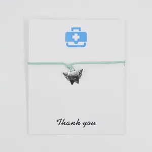 Mint green wax cord bracelet with a winged angel tooth charm on a Thank You card