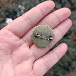 Detailed macro view showing the vintage bronze metal pin back of a round time gem brooch accessory
