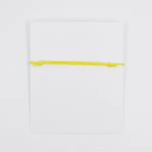 Minimalist yellow wax cord wish bracelet wrapped on a plain white gift card for dentists