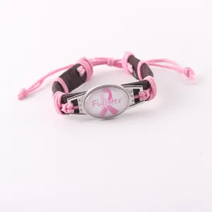 Detalle de la pulsera de la cinta rosa contra el cáncer de mama con el texto Fighter.