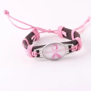 Detalle de la pulsera de cuero trenzado con lazo rosa contra el cáncer