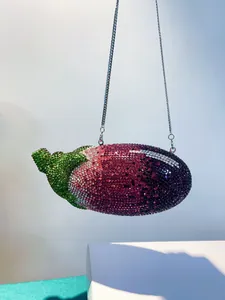 Detailansicht einer funkelnden Abendtasche in Auberginenform mit Strass und Kette