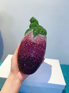 Auberginen-Abendtasche mit glitzerndem Farbverlauf aus lila und grünen Kristallen in der Hand.