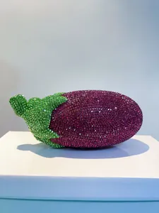 Detailansicht einer auberginenförmigen Abendtasche mit lila und grünen Strass