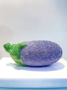 Nahaufnahme einer lila Auberginen-Abendtasche mit glitzernden Kristallen verziert