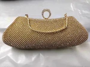 Vista de cerca de bolso de noche de strass dorado con cierre de anillo de cristal