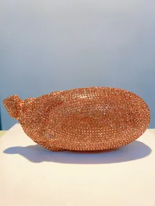 Detailansicht der funkelnden, orangefarbenen, mit Strass besetzten Abendtasche in Auberginenform