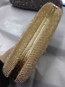 Primer plano de bolso de fiesta con pedrería dorada que muestra detalles de bisagra