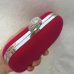 Detail of fuchsia velvet evening clutch bag featuring a sparkling rhinestone ring clasp.