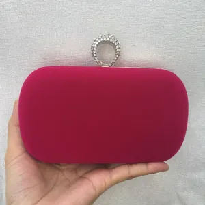 Handheld hot pink velvet evening clutch bag with sparkling rhinestone ring clasp detail