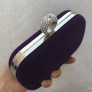 Detailed side view of purple velvet clutch with rhinestone-encrusted ring clasp.