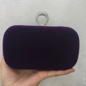 Close-up view of luxury purple velvet evening clutch with sparkling rhinestone ring clasp