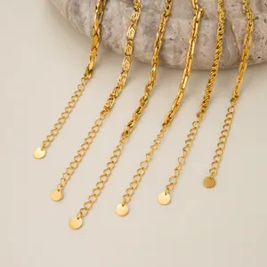 Detailed view of multiple gold vintage chain necklaces and bracelets on marble base.