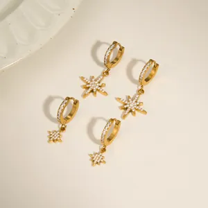 Detailed view of 18k gold plated stainless steel huggie earrings with CZ star charms.
