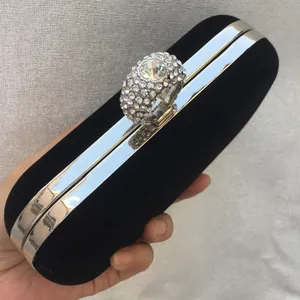 Close-up of black velvet evening clutch with a luxury rhinestone ring clasp