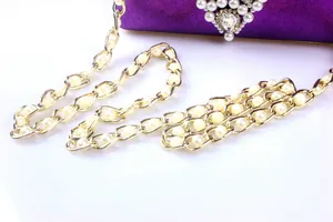 Detailed close-up view of elegant gold-tone pearl chain strap for purple evening bag