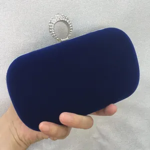 Close-up detail of a luxurious royal blue velvet clutch bag with a sparkly rhinestone ring clasp