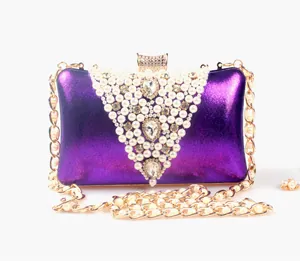 Elegant purple evening clutch bag featuring V-shaped pearl embroidery and a gold chain strap.