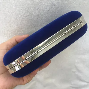 Close-up detail of the metal hinge and frame on a royal blue velvet evening clutch bag