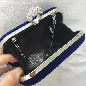Detail view of velvet evening clutch with sparkling rhinestone ring clasp and silver chain