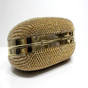 Detail of a gold evening clutch bag featuring a dense rhinestone-encrusted exterior.