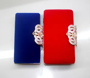 Red and blue velvet evening clutch bags with ornate rhinestone-encrusted crown clasps.
