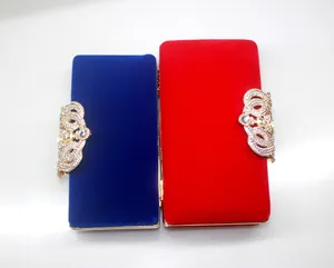 Elegant velvet evening clutches in blue and red with ornate crystal crown clasps