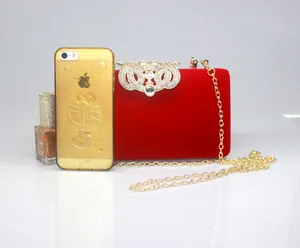Luxury red velvet evening clutch bag featuring a sparkling rhinestone crown clasp