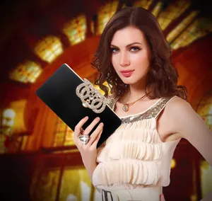 Close-up of elegant black velvet evening clutch with sparkling crystal crown ornament
