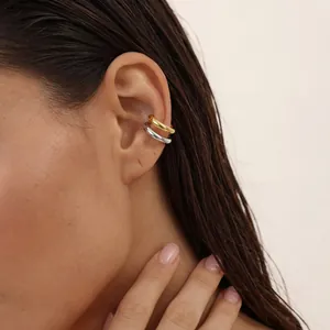 Nahaufnahme eines minimalistischen zweifarbigen Doppelring-Ohrklemmers in Gold und Silber.