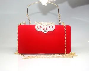 Elegant red velvet evening clutch bag featuring a golden crown rhinestone clasp detail