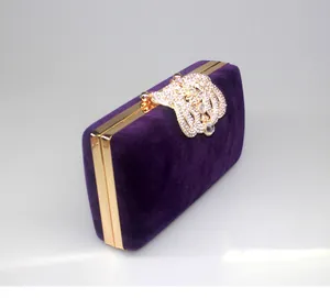 Elegant purple velvet evening clutch bag with a sparkling rhinestone crown shaped clasp