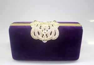 Exquisite detail of a purple velvet evening clutch bag featuring a large ornate crystal clasp