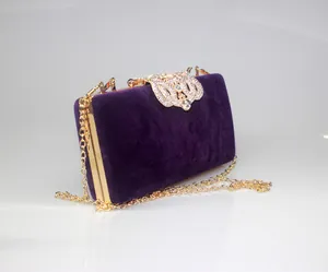 Detailed view of luxury purple velvet clutch bag with crown rhinestone clasp