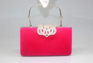 Ornate magenta velvet evening clutch bag with sparkling rhinestone crown clasp detail.