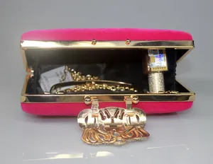 Detailed interior view of a hot pink velvet evening clutch with a golden crown clasp