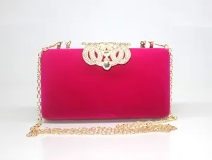 Fuchsia velvet clutch bag with elegant golden rhinestone crown clasp and chain strap