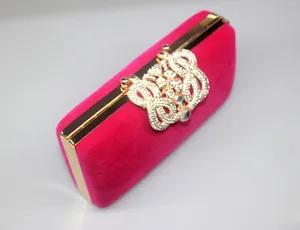 Detailed view of the hot pink velvet dinner clutch with its crystal-encrusted ornate clasp